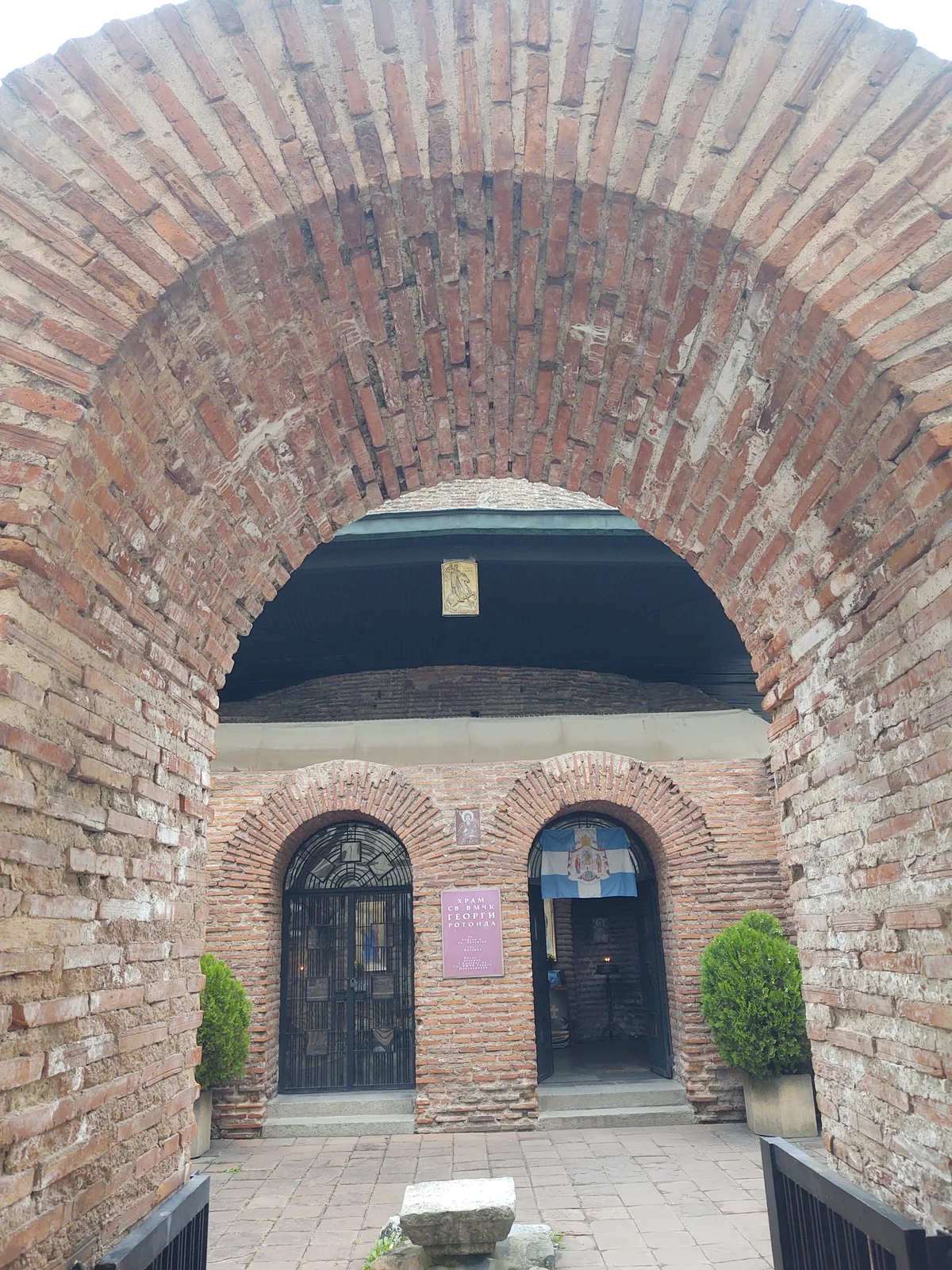 Roman brick arched entrance portal to the Church of St George Rotunda with Cyrillic dedicatory plaque