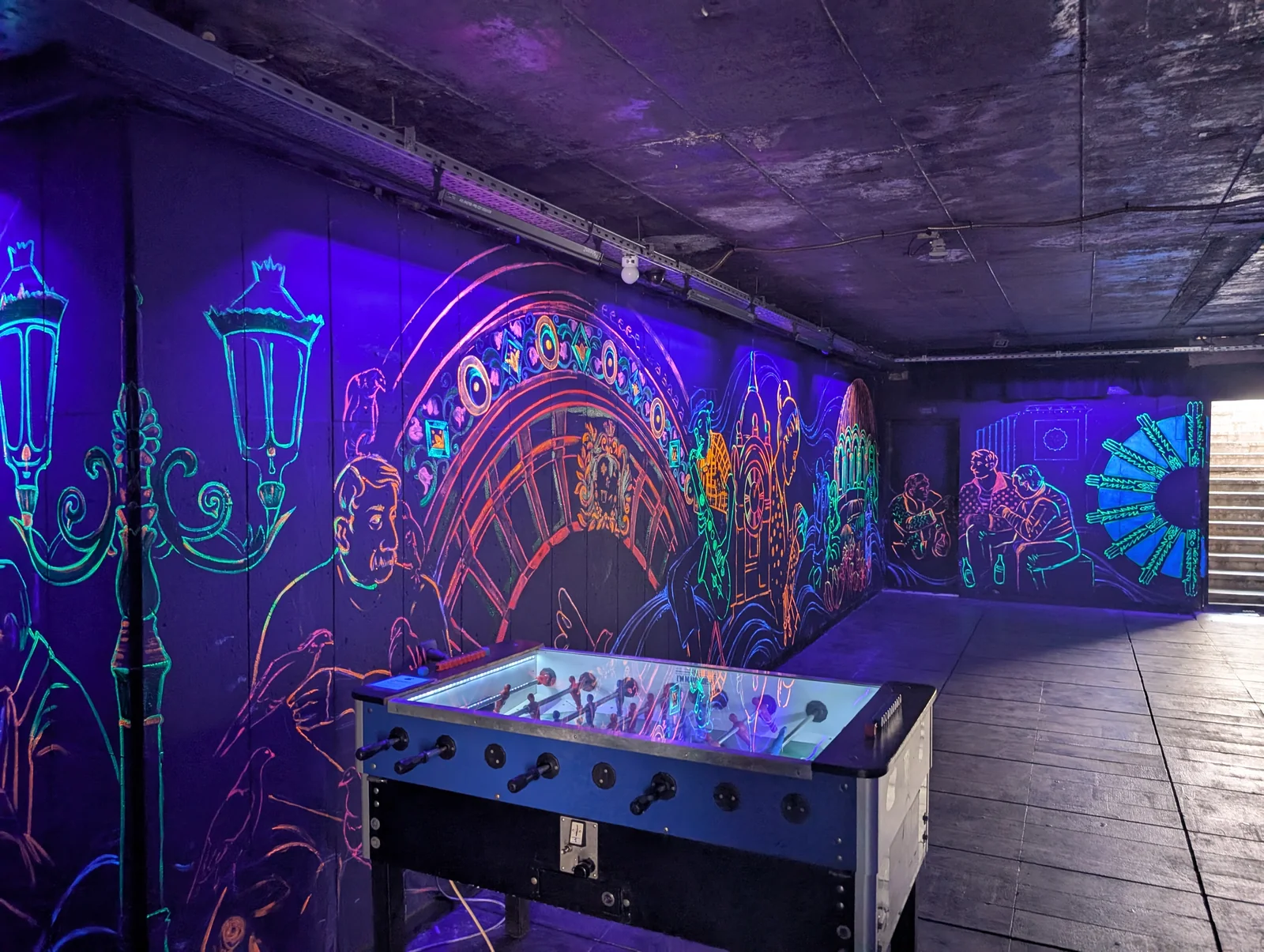 Fluorescent UV street art murals and illuminated table football foosball in Sofia pedestrian underpass